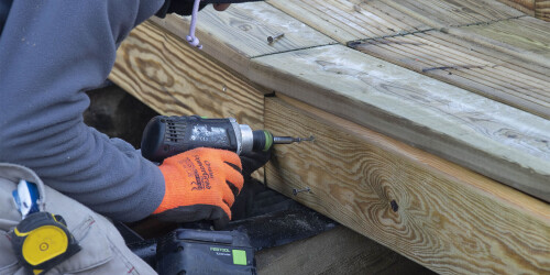 Métier du Zoo : Menuisier - Domaine d'activité : Construction et Rénovation - Menuisier utilisant une perceuse pour fabriquer une terrasse en bois