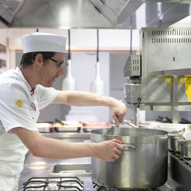 Métier du Zoo : Équipier de restauration cuisine - Emploi - ZooParc de Beauval - Commis de cuisine touillant dans une marmite