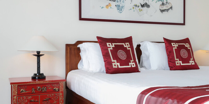 Chambre inspirée de la Chine avec une table de chevet, une lampe et un lit