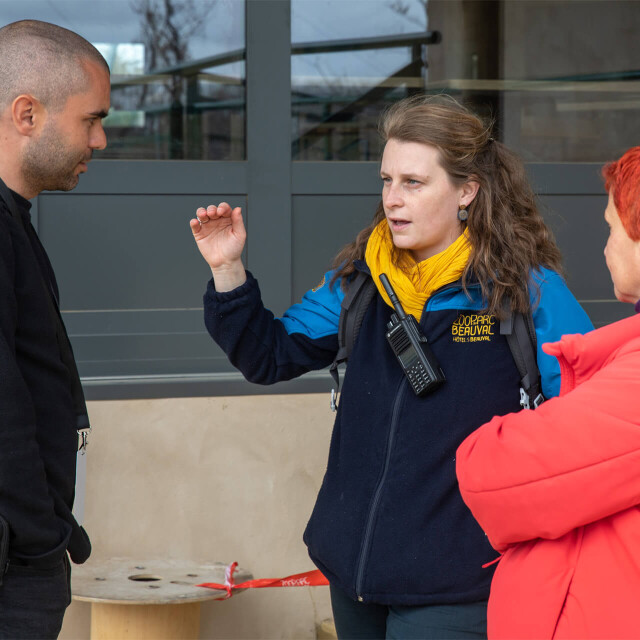 Métier du Zoo : Chargé de Communication Interne et Evenementiel - Emploi - ZooParc de Beauval - Employée avec talkie-walkie discutant avec des visiteurs du ZooParc de Beauval