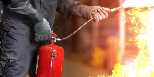 Métier du Zoo : Agent de Sécurité Incendie - Domaine d'activité : Sécurité - Homme utilisant un extincteur pour stopper un départ de feu